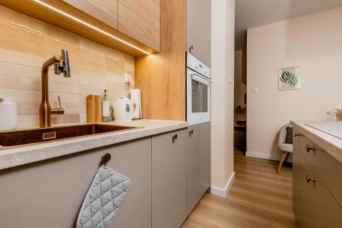 una cucina con lavello e microonde di Matisse Apartment a Białystok