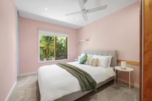 een slaapkamer met een groot wit bed met een raam bij Barramundi Beach House in Smiths Beach