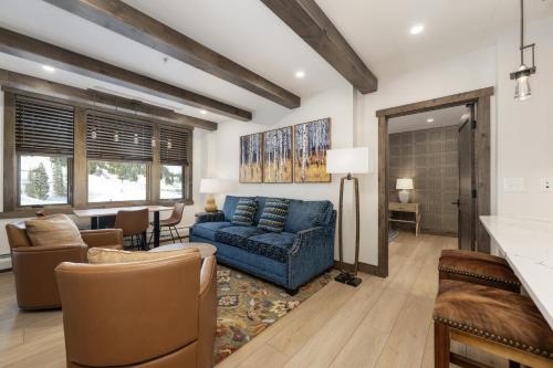 a living room with a blue couch and a table at Select Unit 2509 - Zephyr Mountain Lodge condo in Winter Park