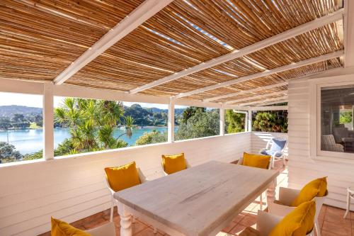 a porch with a wooden table and chairs at Boatsheds on the Bay, Waiheke Island in Ostend