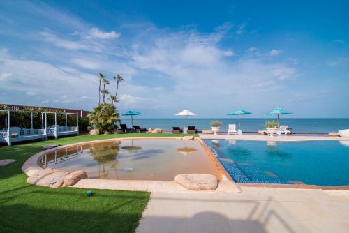 a swimming pool with the ocean in the background at My Resort Hua Hin Service Apartment with Seaview in Hua Hin