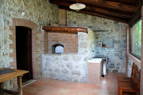 una cocina de piedra con horno de ladrillo en una habitación en Nonno Domenico, en Sassano