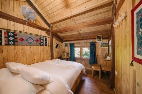 een slaapkamer met 2 bedden in een kamer met houten wanden bij TVpalm Ecolodge in Ha Giang