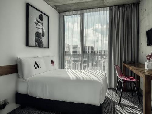 a hotel room with a bed and a window at rõõm collective in Odiongan