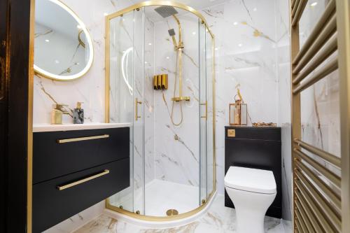 a bathroom with a toilet and a glass shower at The Apartment in Paisley