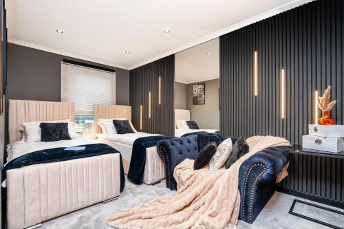 a room with three beds and chairs in it at The Apartment in Paisley