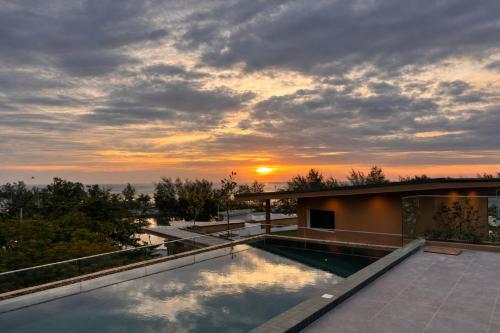 a sunset on the roof of a house with a swimming pool at The Proud Karon Beach Phuket Trademark Collection By Wyndham in Karon Beach
