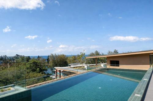 a swimming pool in the backyard of a house at The Proud Karon Beach Phuket Trademark Collection By Wyndham in Karon Beach