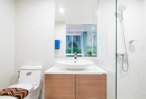 uma casa de banho com um lavatório branco e um chuveiro em My Resort Hua Hin Service Apartment with Seaview em Hua Hin