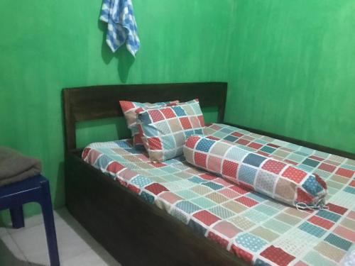 een bed met een quilt erop in een kamer bij Mudung Keramat Homestay in Sapit