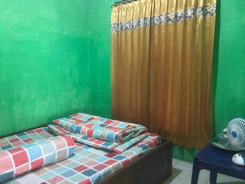 een kamer met 2 bedden en een groene muur bij Mudung Keramat Homestay in Sapit