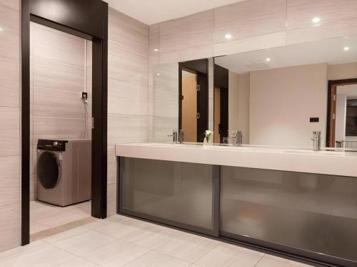 a bathroom with a sink and a washing machine at Green Tree Inn Nanchang Zhongshan Road Bayiguan in Nanchang