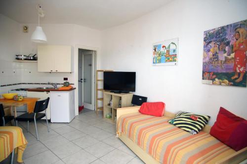 sala de estar con sofá y cocina en Appartamenti Mare Blu, en Isola Rossa