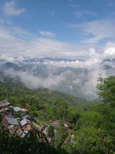 een uitzicht op een berg met wolken in de verte bij Jun Homestay in Kalimpong