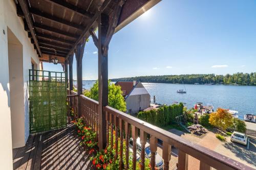 a balcony with a view of the water at Pensjonat Mikołajki in Mikołajki