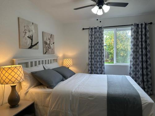 a bedroom with a bed with a ceiling fan and a window at Cozy suite B in Sacramento