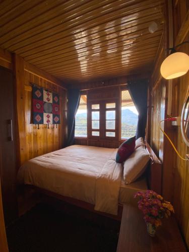una camera da letto con un letto in una stanza con una finestra di Sen Sapa Retreat & Tours a Sa Pa