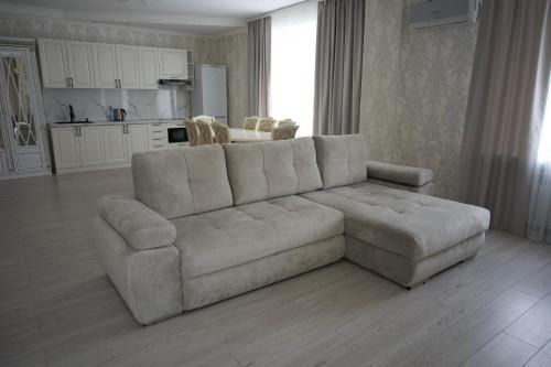 a living room with a couch and a kitchen at Гостиница Караганда in Karagandy