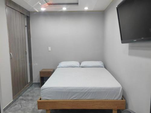 ein Schlafzimmer mit Bett und Flachbildfernseher in der Unterkunft Quiet space near Nórdica with parking in Bello