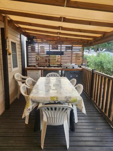 einen Tisch und Stühle auf einer Holzterrasse in der Unterkunft Camping Siblu Bella Vita in Canet-en-Roussillon