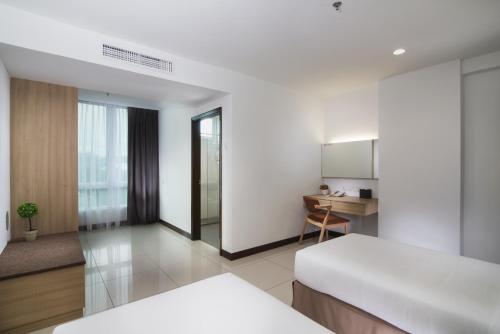 a hotel room with a bed and a desk at One Pacific Hotel and Serviced Apartments in George Town