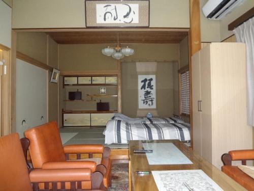a living room with a bed and a table and chairs at Mokkoan in Tokyo