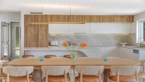 a kitchen with a large wooden table with chairs at 'Ocean Pearl' by HolidayCo in Hardys Bay