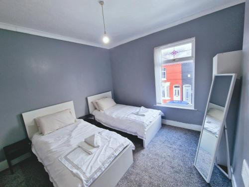 ein kleines Zimmer mit zwei Betten und einem Fenster in der Unterkunft Stylish Modern Home comfy setting by Everton Park in Liverpool