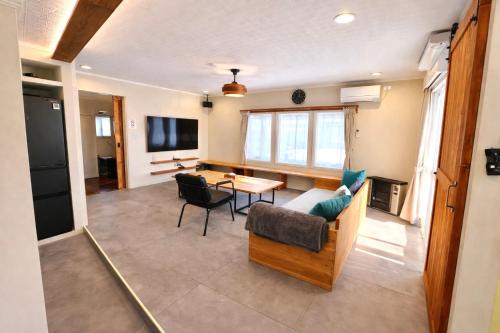 a living room with a couch and a table at ベースクラウン プライベート温泉付き ペット可 in Shiraoi