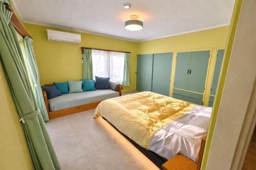 a bedroom with a bed and a couch in it at ベースクラウン プライベート温泉付き ペット可 in Shiraoi