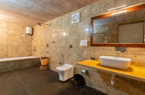 斋沙默尔Desert Villa Resort & Camp Jaisalmer的浴室里有洗手池、马桶和镜子。