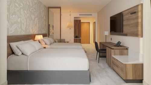 a hotel room with two beds and a television at Hyatt Place Cancun Airport in Cancún