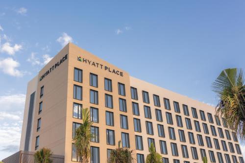 a tan building with a martinez palace sign on it at Hyatt Place Cancun Airport in Cancún