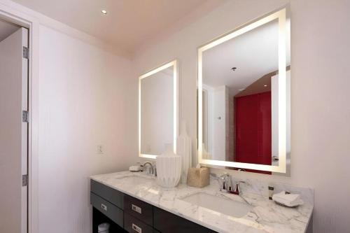 ein Badezimmer mit Waschbecken und zwei Spiegeln in der Unterkunft Ahern Hotel and Event Center in Las Vegas