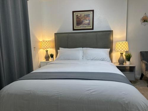 a bedroom with a large white bed with two lamps at Kitchen Suite A in Sacramento