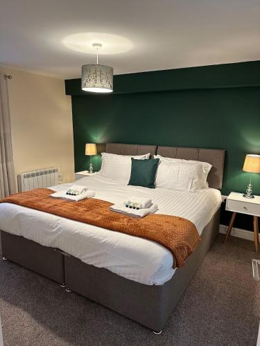 a bedroom with a large bed with two towels on it at Orange Lilly in Stroud with Free Parking in Stroud