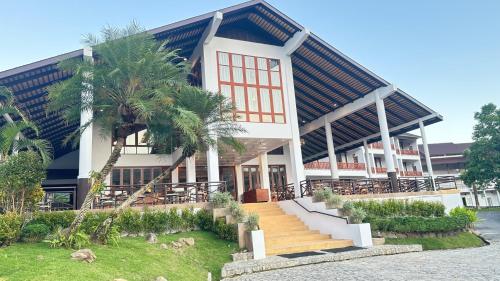 ein Gebäude mit einer Palme davor in der Unterkunft Belle Villa Resort, Chiang Mai in Ban Pong