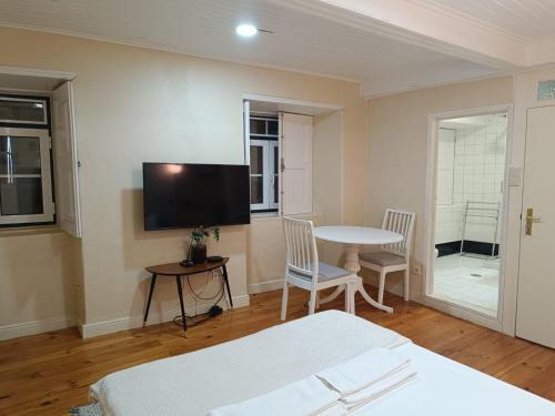 una stanza con un letto, un tavolo e una tv di Bragança Apartamento Studio a Bragança