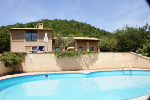 ein Haus und ein Pool vor einem Haus in der Unterkunft Re Artù Assisi Country Lifestyle in Assisi
