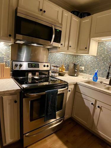 a kitchen with a stainless steel stove top oven at Cozy Downtown Cottage - Parking, Pet Friendly! in Wilmington