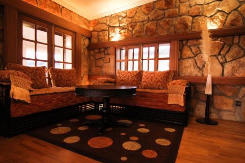 a room with a couch and a table in a stone wall at Rise In Valley in Ifrane