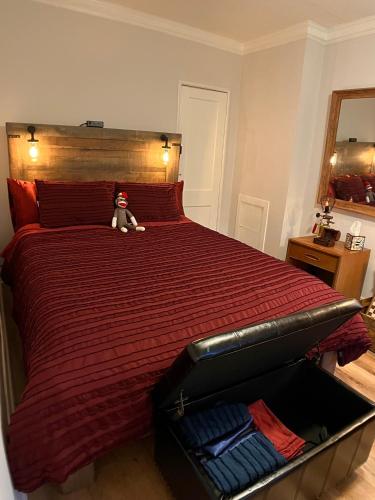 a red bed with a teddy bear sitting on it at Cozy Downtown Cottage - Parking, Pet Friendly! in Wilmington