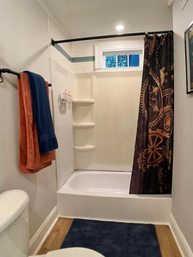a bathroom with a tub and a toilet and a shower at Cozy Downtown Cottage - Parking, Pet Friendly! in Wilmington