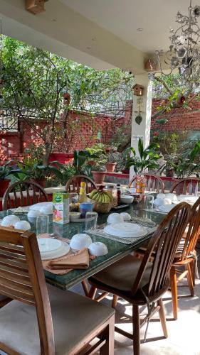 un tavolo con piatti e ciotole, con sedie di Gorayya Villa Luxury Rustic 4BHK Mussoorie Foothills a Dehradun