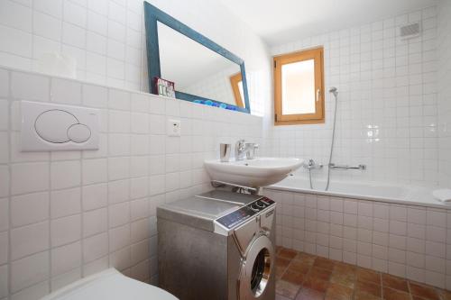 a bathroom with a toilet and a sink and a tub at Apartment Avouitzons 220 in Verbier