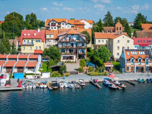 a group of boats are docked in a harbor at Pensjonat Mikołajki in Mikołajki