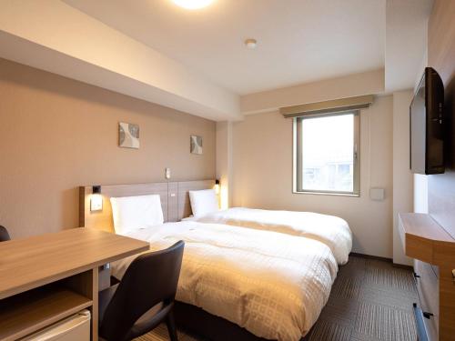 a hotel room with a bed and a desk and a window at Comfort Inn Kofu Showa Inter in Kofu