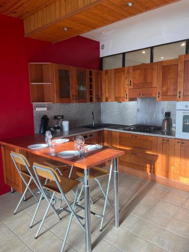 a kitchen with wooden cabinets and a wooden table at Appartement 3 Pièces, Neuvecelle in Neuvecelle