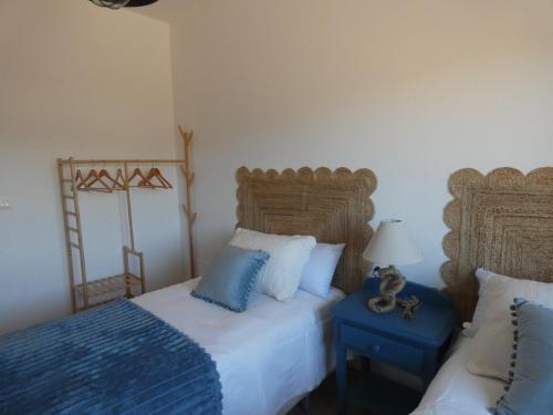 una camera con 2 letti con cuscini blu e bianchi di El Refugio de Hugo a Benablón