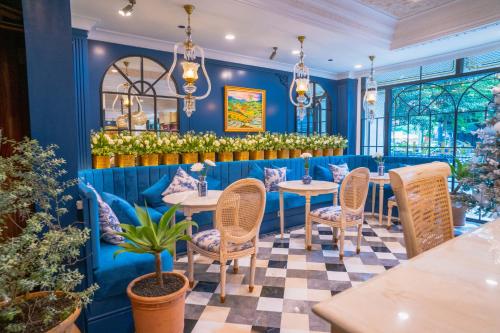a restaurant with blue walls and tables and chairs at Le Meridien Jakarta in Jakarta